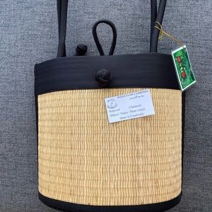 New with tags, handwoven grass and black nylon handbag.